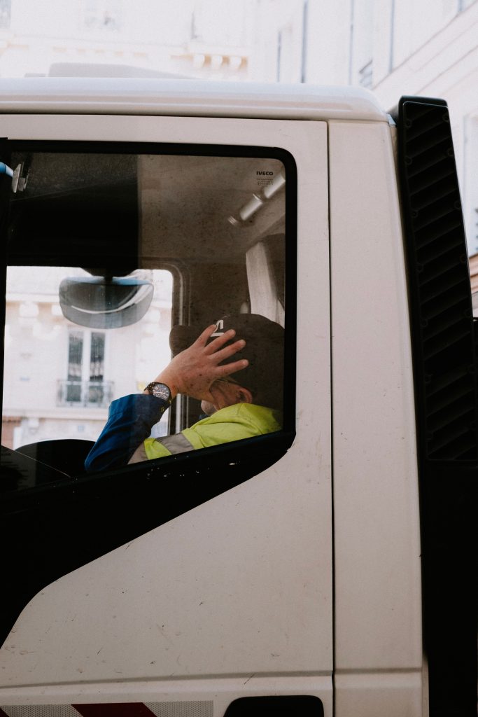Șofer profesionist în cabina unui camion, ilustrând legătura dintre învățarea teoretică și condus.