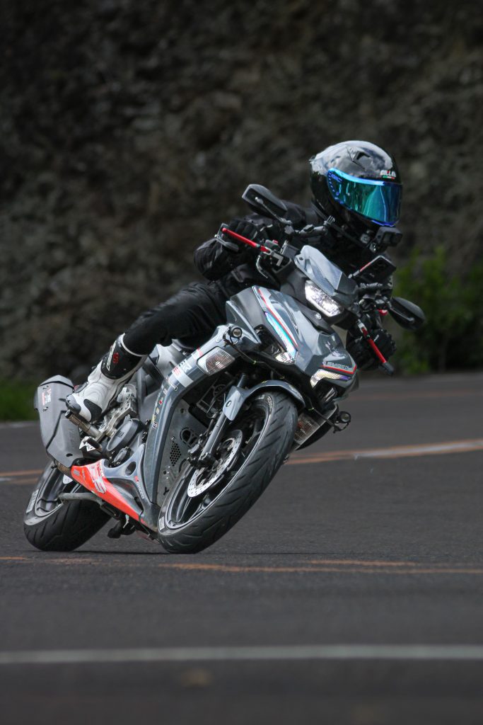 Capture the thrill of a motorcyclist navigating a sharp road bend with precision.