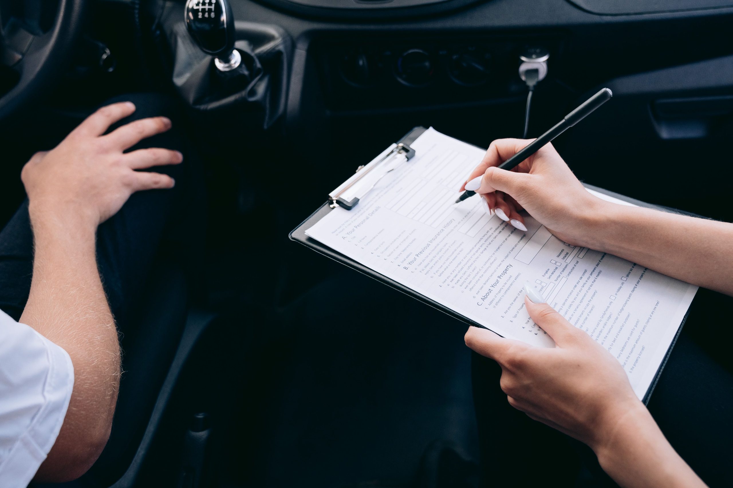 Notițe pe clipboard în cabina vehiculului, pentru verificarea activității șoferului profesionist.